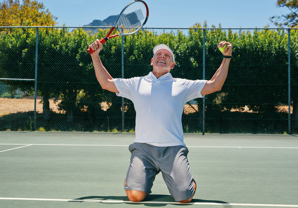 I am the man. a handsome mature man celebrating a win while playing tennis during the day - Foto, imagen