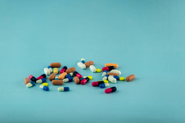 Simple pile of colorful pills. Medicines, pills stacked on blue background. Medical supplies. - Foto, Imagen