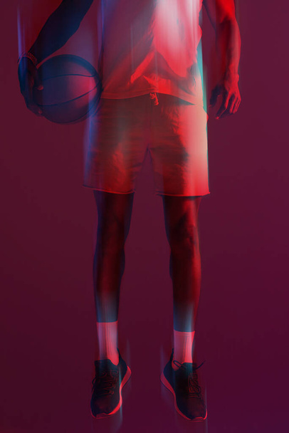 Ready to take it to the next level. Red filtered shot of an unrecognizable sportsman posing with a basketball in the studio - Fotó, kép