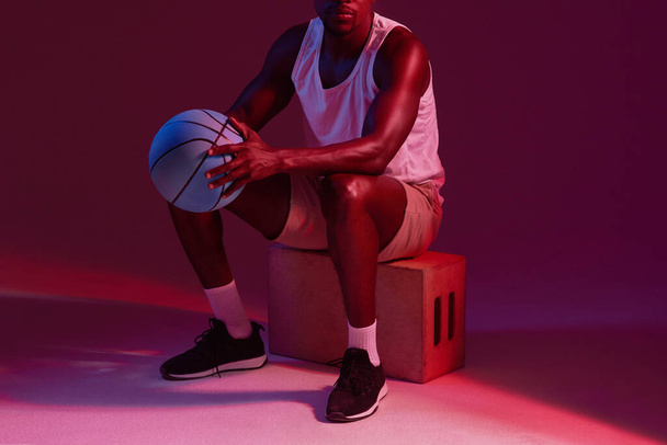 Theres no off season. Red filtered shot of an unrecognizable sportsman posing with a basketball in the studio - Фото, изображение