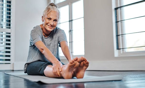 Remamber to rest in between. Portrait of a cheerful mature woman practicing yoga inside of a studio during the day - Foto, Imagen