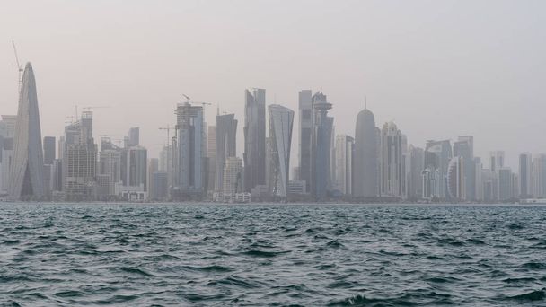 Qatar skyline with rough sea in the foreground on a windy and rainy day. - Foto, imagen