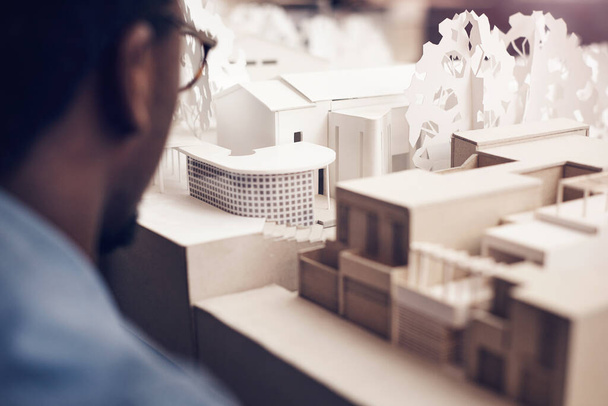 The work of a great architect. an unrecognizable male architect looking at a scale model while working in a modern office - Foto, afbeelding