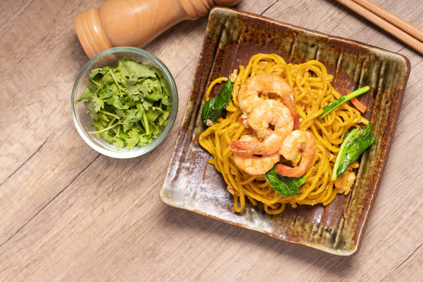 Fried noodles with shrimp in a plate on the table - Fotoğraf, Görsel