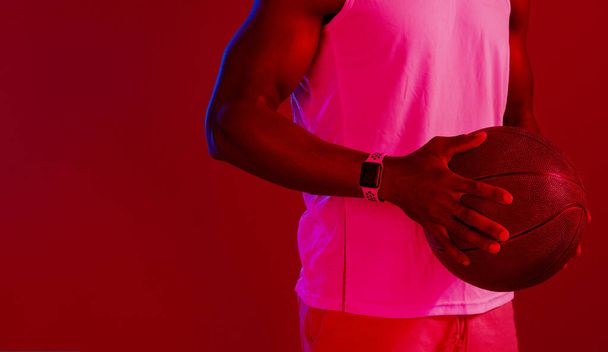 Keep practicing until you get it right. Red filtered shot of an unrecognizable sportsman posing with a basketball in the studio - Foto, afbeelding