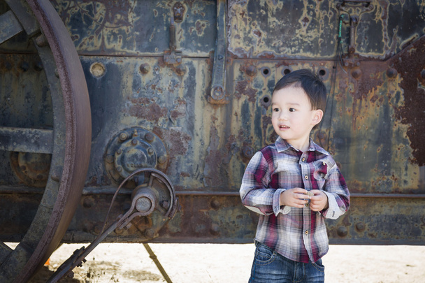 Schattig jong gemengd ras Boy plezier in de buurt van antieke machines - Foto, afbeelding