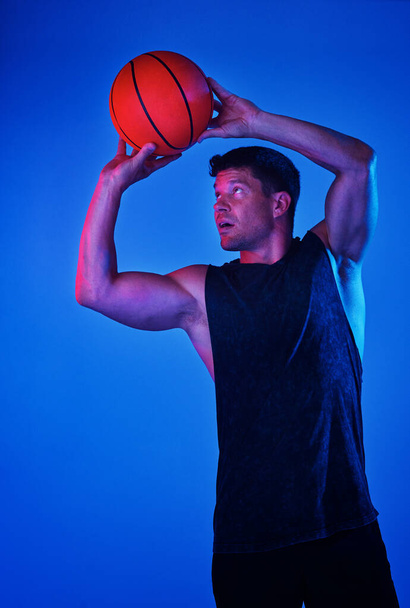 I never miss a shot. Red filtered shot of a sportsman playing basketball in the studio - Foto, Imagen