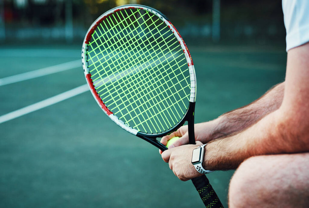 Сегодня я выйду на новый уровень. Крупный план неузнаваемого человека, держащего теннисную ракетку и мяч на теннисном корте - Фото, изображение