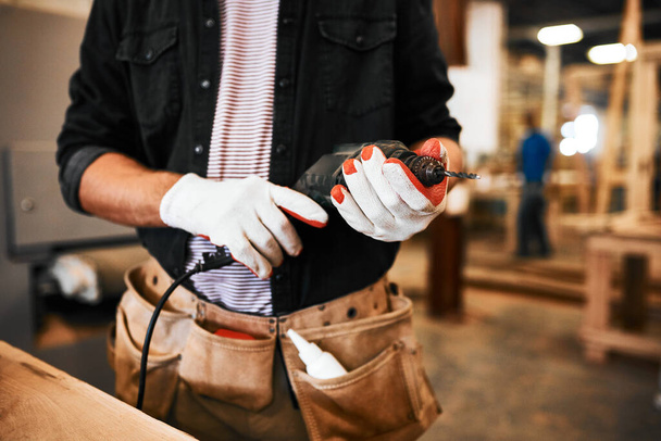 Im ready to get my drill on. an unrecognizable carpenter holding an electric drill inside a workshop - Foto, imagen