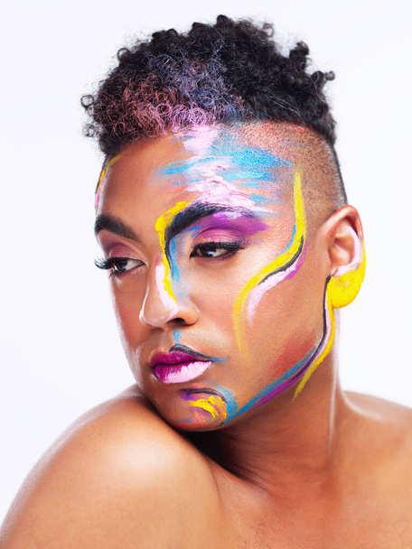Were all living in a world of color. a gender fluid young man wearing face paint against a white background - Foto, afbeelding