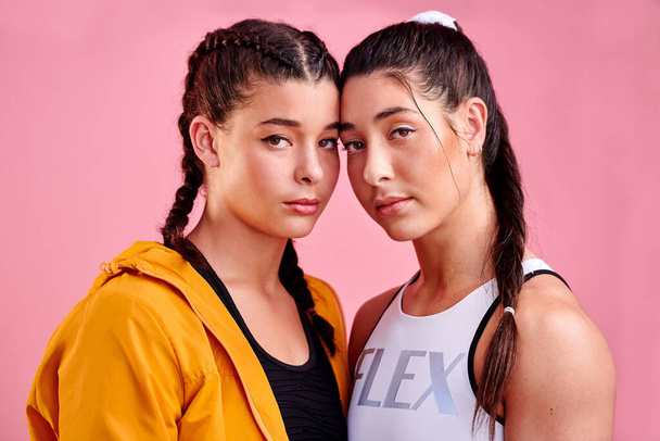 Double the fierceness. Studio portrait of two sporty young women standing together against a pink background - Foto, Bild