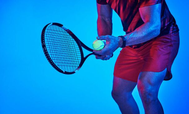 Find something youre good at and stick to it. Blue filtered shot of an unrecognizable tennis player getting ready to serve - Photo, image