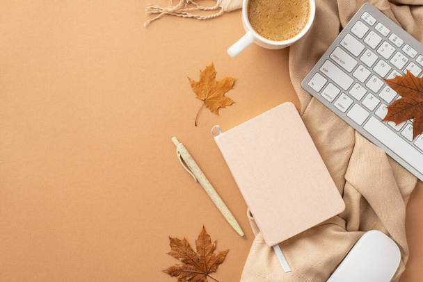 Autumn business concept. Top view photo of planner pen computer mouse keyboard cup of coffee yellow maple leaves and plaid on isolated beige background - Foto, Bild