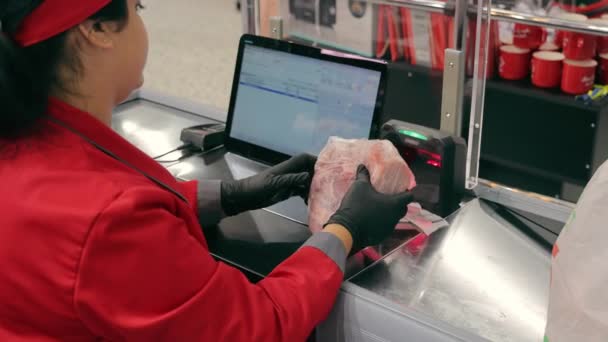 The cashier at the supermarket checkout scans the bar code of the product. The seller enters information about the purchase into the computer. - Video