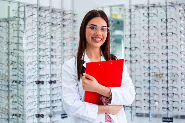 smiling ophthalmologist standing with diagnosis in clinic - Photo, Image