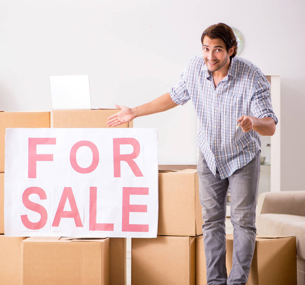 Der junge Mann bietet seine Wohnung zum Verkauf an und zieht aus - Foto, Bild