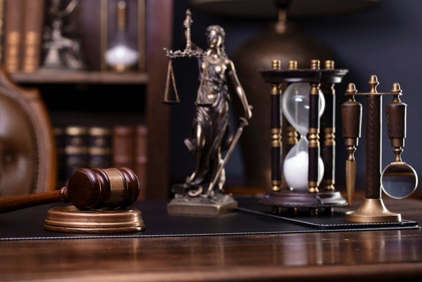 Law theme - judge office. Themis and gavel  on the judge desk. Book shelf  in the background. - Foto, Imagen