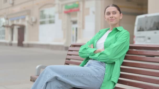 Νεαρή γυναίκα στέκεται και αφήνοντας Bench Εξωτερική - Πλάνα, βίντεο