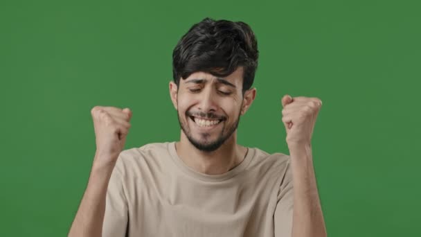 Happy surprised hispanic man looking at camera rejoice victory luck feel happiness triumph emotional young arab guy excited amazing news portrait shocked enthusiastic male celebrate victory in studio - Video, Çekim
