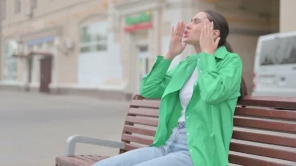 Θυμωμένη νεαρή γυναίκα αισθάνεται απογοητευμένος, ενώ κάθεται σε εξωτερικό χώρο στο Bench - Πλάνα, βίντεο