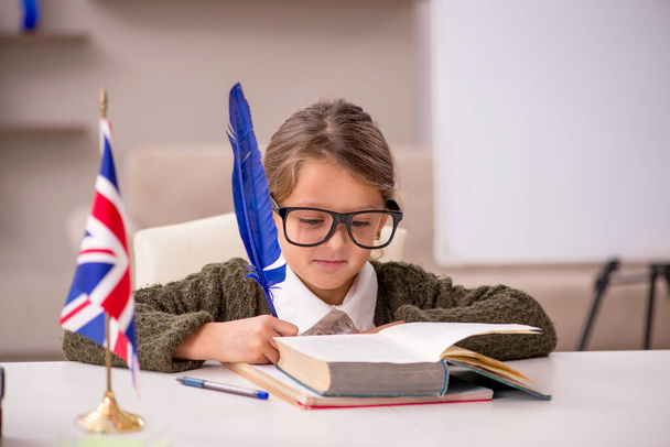 Молода маленька дівчинка вивчає англійську мову вдома
 - Фото, зображення