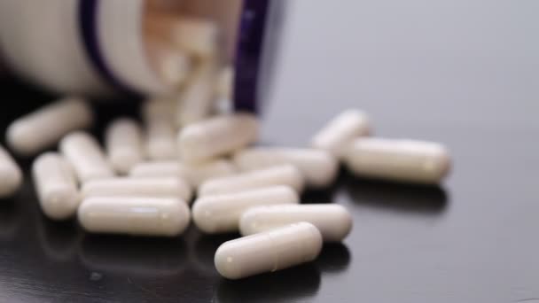 Bílé oválné tablety leží poblíž láhev - Záběry, video