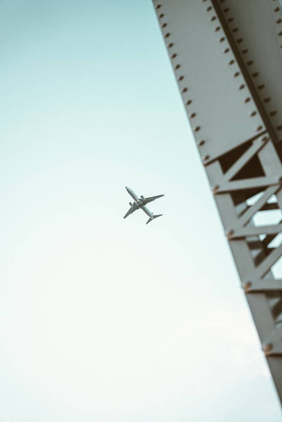 Ein Tiefflug eines Flugzeugs, das gegen einen bewölkten Himmel fliegt - Foto, Bild