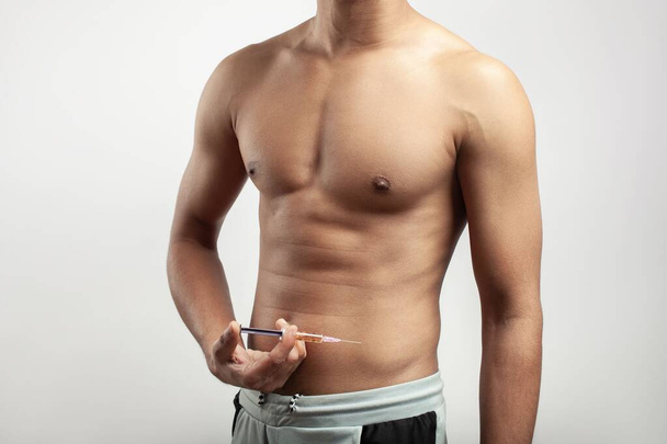 muscular male body injecting anabolic steroid or athletic drug into his body - Fotoğraf, Görsel