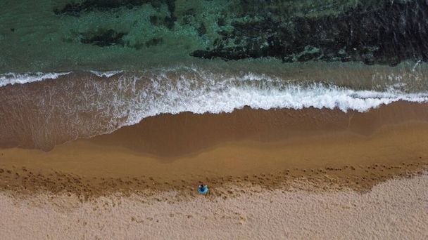 A man on a sandy beach controlling the drone with remote control - Фото, зображення