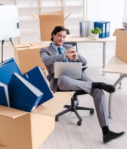 Молодой человек с коробками в офисе - Фото, изображение