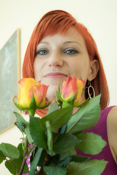 Go Everywhere with flowers woman. A girl with red hair and a great smile - Foto, immagini