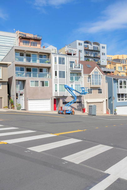 Pedestrian lane near the residential area in San Francisco, California. There is a view of complex residences across the street with boom lifter at the front. - Foto, Imagen