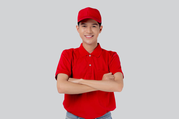Young asian man in uniform red and cap standing arms crossed with confident isolated on white background, employee or dealer, courier and delivery, deliveryman and expression, logistic and cargo. - Photo, Image