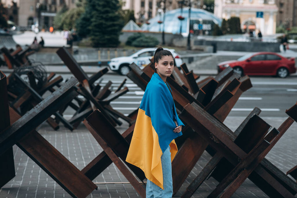 Mujer joven con bandera nacional de Ucrania caminando por la ciudad - Foto, imagen