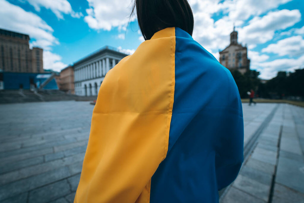 Young woman with national flag of Ukraine walking in the city - Fotoğraf, Görsel
