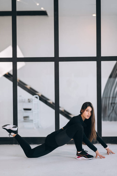 Side view of flexible girl exercising yoga pose indoors. Concept of yoga. - Valokuva, kuva