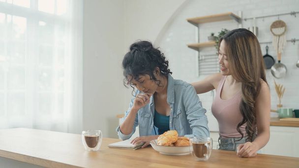 Holiday concept of 4k Resolution. Asian women having coffee together in the kitchen. Young women are in a mutual lesbian love relationship. - Photo, image