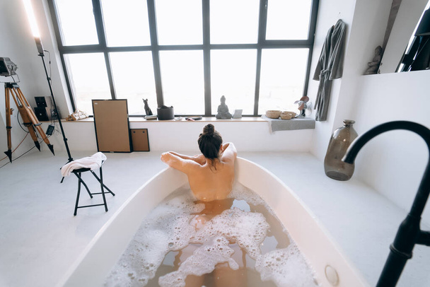 Happy woman bathing at home. Relaxation and wellness, back view - Foto, Imagem