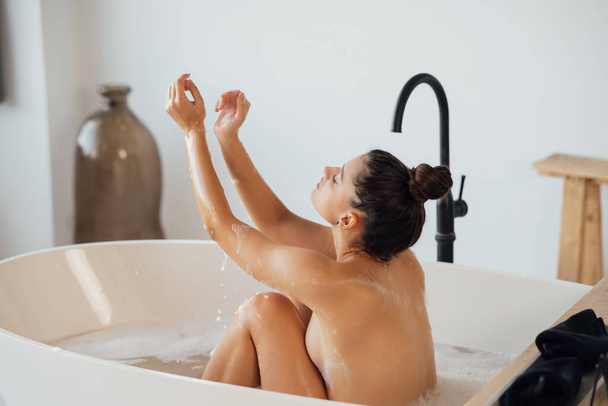 Mujer bastante joven tomando baño en casa - Foto, Imagen