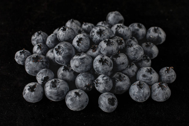 Handful of blueberries on black background. Handful of blueberries Ripe berries. Healthy Lifestyle. Useful products. Lots of vitamins. - Foto, Imagen