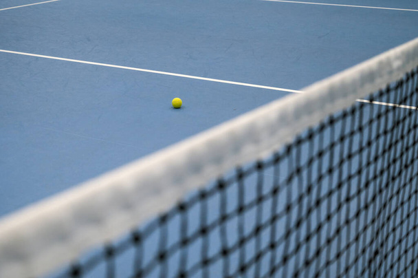 Empty blue tennis court. Tennis net and ball. - Zdjęcie, obraz