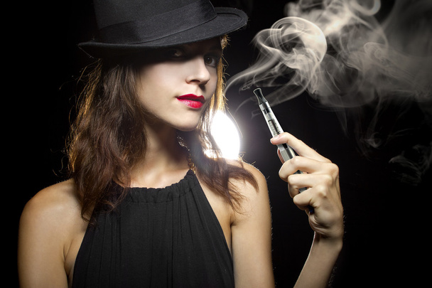 Woman vaping an electronic cigarette - Foto, afbeelding