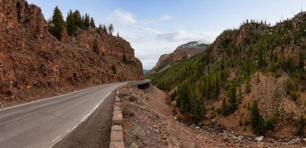 Scenic Road in the American Landscape. Yellowstone National Park, Wyoming. Cloudy Sky Art Render. United States. Nature Background Panorama - Photo, Image