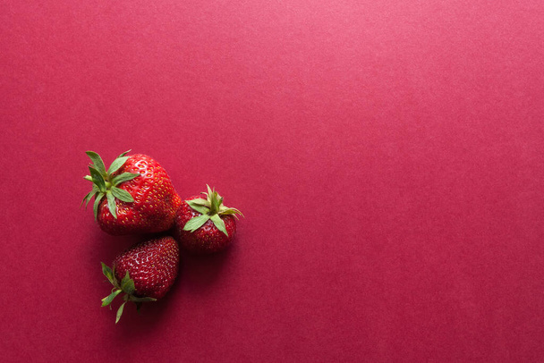 Φράουλες σε κόκκινο φόντο. Έννοια φαγητού. Αντιγραφή χώρου - Φωτογραφία, εικόνα