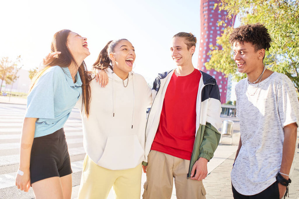 Group of young people having fun together outdoors. Portrait of multiethnic students laughing at the city. High quality photo - Photo, Image