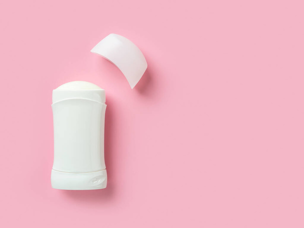 Solid antiperspirant over pink background with copy space. Open white plastic tube of body deodorant close-up. Toiletries for reduce perspiration, hygiene and body care concepts. Front view. - Valokuva, kuva