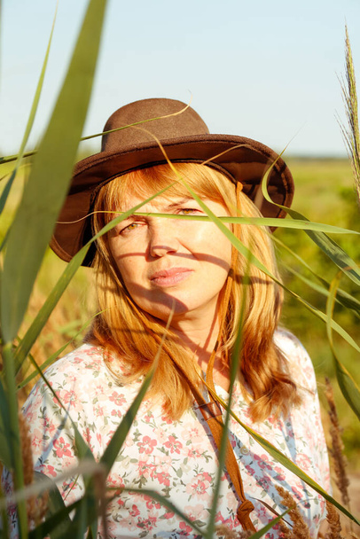 Defocus closeup outdoor portrait of beautiful young blonde woman near reed and pampas grass. Plant art shadows. Cowgirl on meadow. Mental health, silence. Countryside, wellness. Out of focus. - Photo, image