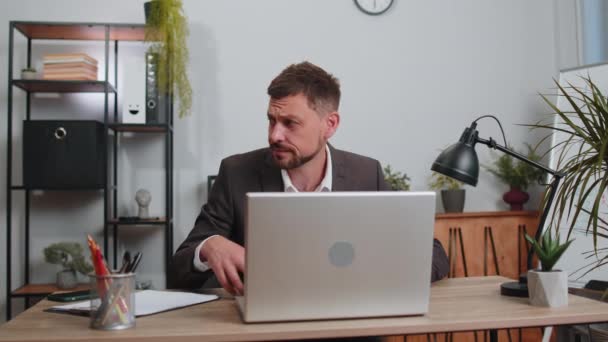 Hopeless sad businessman in formal wear suit working on laptop computer, showing inscription note text Help. Overworked tired freelance business man indoors at office. Poverty, bankrupt, deadline - Metraje, vídeo