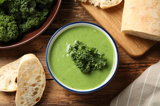 Tasty kale soup on wooden table, flat lay - Foto, immagini
