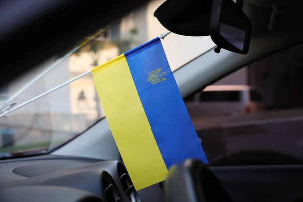 National flag of Ukraine on windshield inside car - Foto, imagen